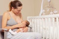 Mother breastfeed newborn infant baby sitting on the chair