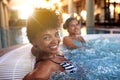 Besties have the best of fun. Portrait of a woman relaxing in a jacuzzi with her friend blurred in the background. Royalty Free Stock Photo