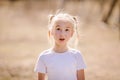 The portrait of wondered blonde girl with two braids