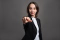 Portrait of wonderful young business woman pointing her finger, poseing on isolated gray background Royalty Free Stock Photo