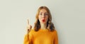 Portrait of wondering surprised young woman pointing her fingers up on white background, blank copy space Royalty Free Stock Photo