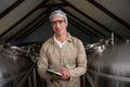 Portrait of worker amidst storage tanks writing on clipboard Royalty Free Stock Photo