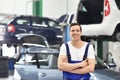 Portrait worker/mechanic in a garage - smiling man in workwear