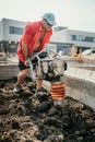 portrait of worker using vibratory tamper soil compactor