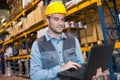 Portrait worker in warehouse with laptop computer