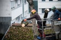 Portrait of workers cutting tree trunk in the street
