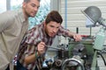 portrait workers watching bench drill