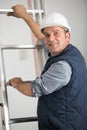 portrait workman with hands on rungs ladder Royalty Free Stock Photo