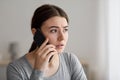 Portrait of worried anxious upset millennial lady talks by phone, received bad news at home