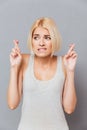 Portrait of worried anxious young woman with fingers crossed Royalty Free Stock Photo