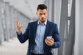 Portrait Of Worried Arab Businessman Reading Message On Smartphone In Airport