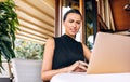 Portrait of a worried business woman smiling and working with laptop in a cafe. Portrait of succesful serious young female manager Royalty Free Stock Photo