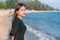 Portrait of a worried girl standing on the beach with green nature and blue sea in the background. Sad and depressed young woman Royalty Free Stock Photo