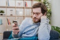 Portrait of worried man on the sofa holding cellphone at home Royalty Free Stock Photo