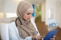 Portrait of worried muslim female Medical doctor holding paperclip in hospital