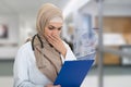 Portrait of worried muslim female Medical doctor holding paperclip isolated