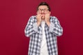 Portrait of worried nervous or stressed middle aged business man in casual checkered shirt and eyeglasses standing, bitting his Royalty Free Stock Photo