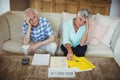 Portrait of worried senior couple checking bills in living room Royalty Free Stock Photo