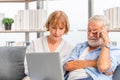 Portrait of Worried senior couple checking their bills and work on netbook read document information at home, Serious retired Royalty Free Stock Photo