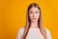 Portrait of worried troubled lady bite lip look side empty space think on yellow background