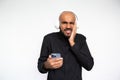 Portrait of worried young man in headphones holding mobile phone Royalty Free Stock Photo