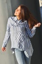 Portrait& x27;s young cool asian girl stands near the wall and posing and she dressed a striped shirt Royalty Free Stock Photo