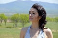 Portrait of 45 year old caucasian brunette woman looking away, with bare shoulders on a green field against the background of the Royalty Free Stock Photo