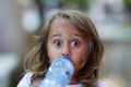 portrait of a 4 year old girl drinking water from a plastic bottle Royalty Free Stock Photo