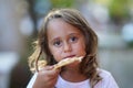 portrait of a 4 year old girl eating a piece of pizza