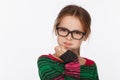 Portrait of 8-year-old girl in glasses and a sweater in a crimson and green stripes. Studio photo session