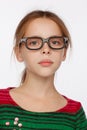 Portrait of 8-year-old girl in glasses and a sweater in a crimson and green stripes. Studio photo session