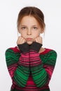 Portrait of 8-year-old girl in with her hair raised up and in a sweater in a crimson and green stripes