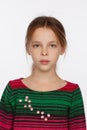 Portrait of 8-year-old girl in with her hair raised up and in a sweater in a crimson and green stripes