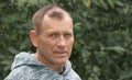 Portrait of a 55-year-old man against a background of greenery