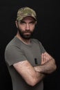 Portrait of a 30-36-year-old man in a military summer uniform, with a beard, army medallions hanging on his chest, black backgroun