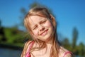 A schoolgirl with rumpled hair smiles into the camera