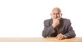 Portrait of 90 year old senior handsome man in suit sitting at the table, thinking and holding his hand on the chin against Royalty Free Stock Photo