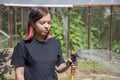 Portrait of a 17-year-old teenage girl watering a vegetable garden with water from a watering hose. Concept: caring for the crop Royalty Free Stock Photo