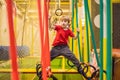 Portrait of 6 years old boy wearing helmet and climbing. Child in abstacle course in adventure playground Royalty Free Stock Photo