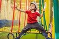 Portrait of 6 years old boy wearing helmet and climbing. Child in abstacle course in adventure playground Royalty Free Stock Photo