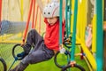 Portrait of 6 years old boy wearing helmet and climbing. Child in abstacle course in adventure playground Royalty Free Stock Photo