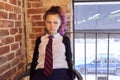 Portrait of 15 years old teenage girl in school uniform with tie sitting on chair Royalty Free Stock Photo