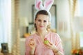 Woman with spoon and egg in modern house in sunny spring day