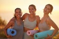 Portrait of yoga women bonding, holding yoga mats in outdoor practice in remote nature. Diverse group of young smiling Royalty Free Stock Photo