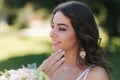 Portrait of yound girl with bouquet. Charming lady in sunny summer day. Stylish woman