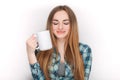 Portrait of a young adorable blonde woman in blue plaid shirt enjoying her warm cozy drink in big blank white mug. Royalty Free Stock Photo