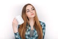 Portrait of a young adorable blonde woman in blue plaid shirt enjoying her warm cozy drink in big blank white mug. Royalty Free Stock Photo