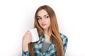 Portrait of a young adorable blonde woman in blue plaid shirt enjoying her warm cozy drink in big blank white mug. Royalty Free Stock Photo