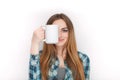 Portrait of a young adorable blonde woman in blue plaid shirt enjoying her warm cozy drink in big blank white mug. Royalty Free Stock Photo