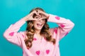 Portrait of young adorable stunning woman in stylish glamour pink cardigan show heart symbol on eye isolated over blue